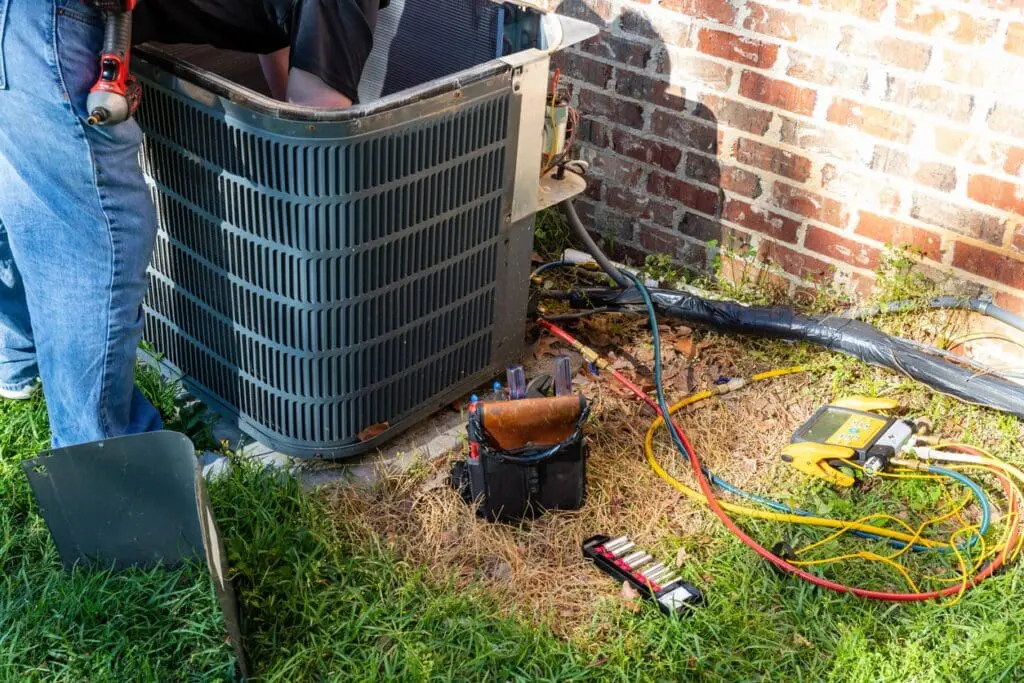 Air conditioner maintenance being performed by HVAC technician