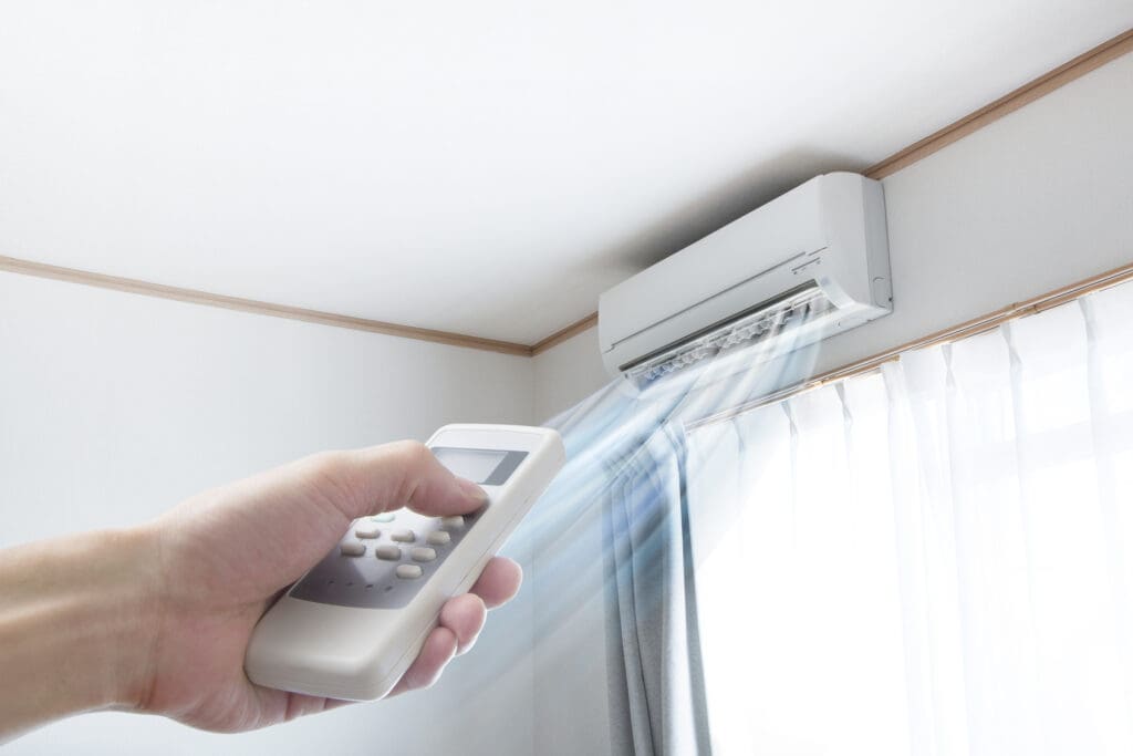hand pointed a ductless unit that's blowing cold air